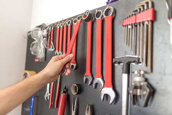 Hand putting tools up in garage