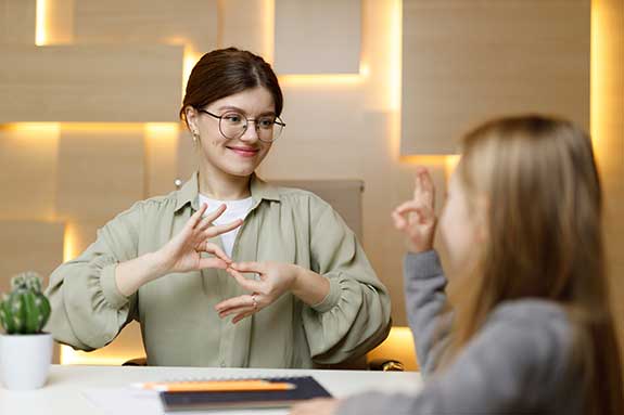 Teacher communicating via sign language with deaf student