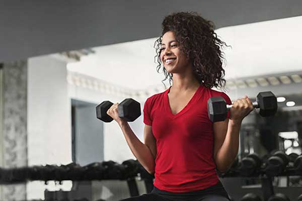 African American woman at gym weight training