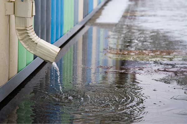 House gutter draining onto pavement