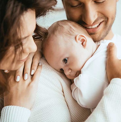 Husband and wife holding baby