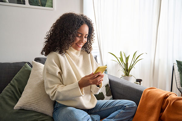 Woman looking at mobile on couch