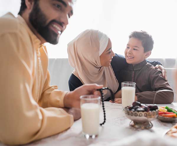 Indian mother at table with son wearing hijab